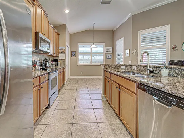 a kitchen with stainless steel appliances granite countertop a refrigerator stove top oven and sink