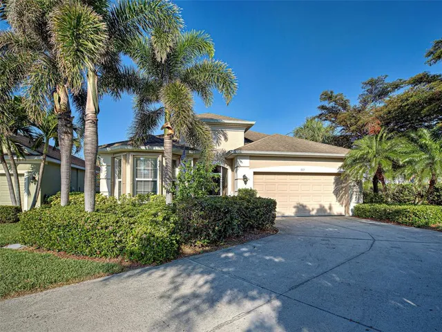 a view of a house with a yard and coconut trees