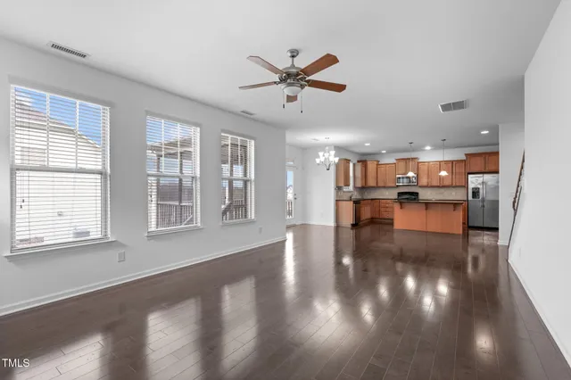 a view of empty room with wooden floor and windows