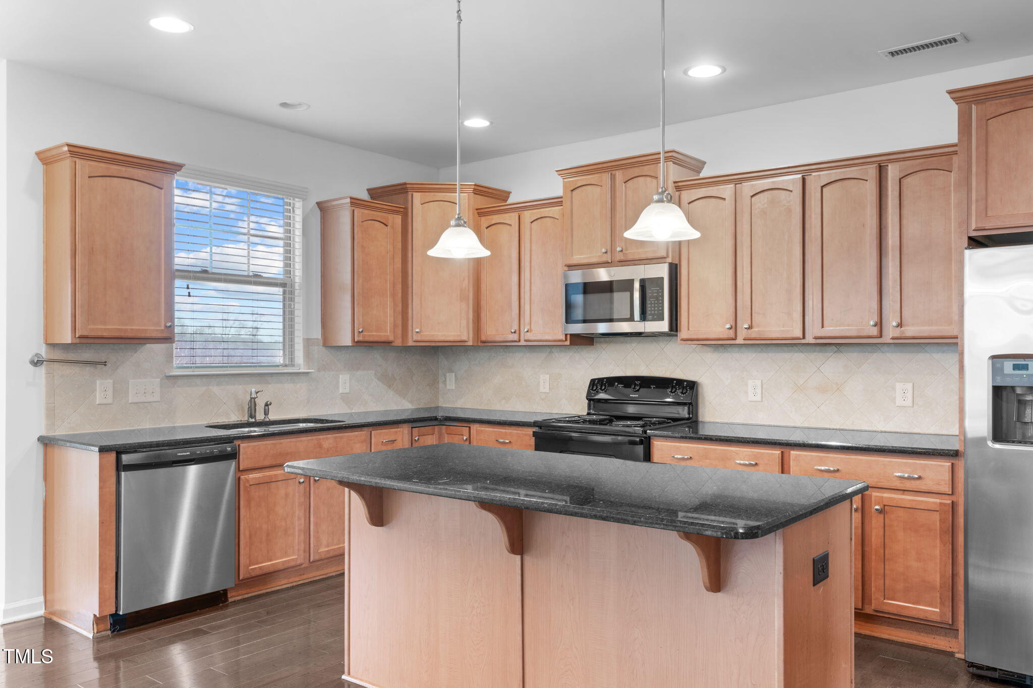 4139 Davis Meadow Street Raleigh, NC 27616 - Photo 16 of 43 a kitchen with stainless steel appliances granite countertop a sink a stove and a microwave