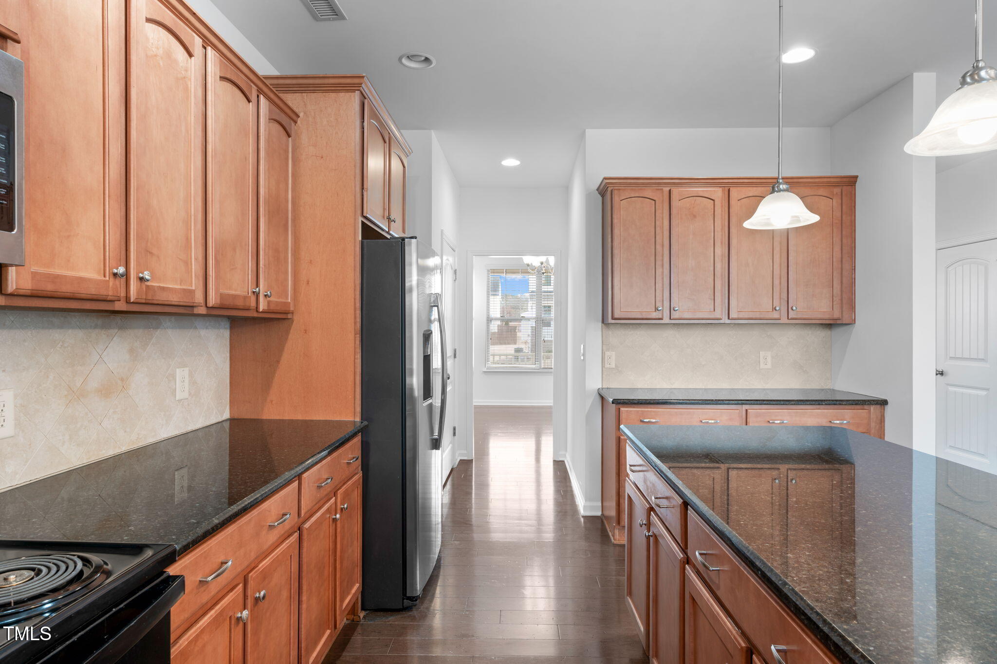 4139 Davis Meadow Street Raleigh, NC 27616 - Photo 19 of 43 a kitchen with stainless steel appliances granite countertop a refrigerator a sink dishwasher and wooden cabinets with wooden floor