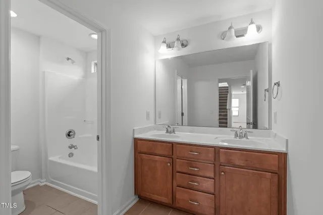 a bathroom with a granite countertop sink mirror and toilet