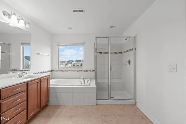 a bathroom with a bathtub shower sink and mirror