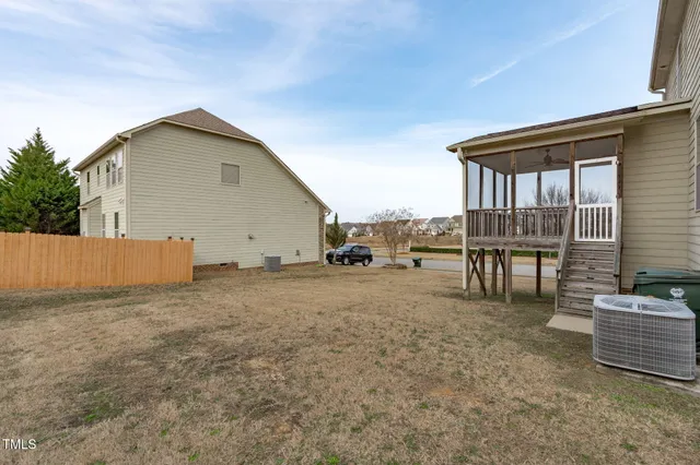 a view of a blue house with large windows next to a road