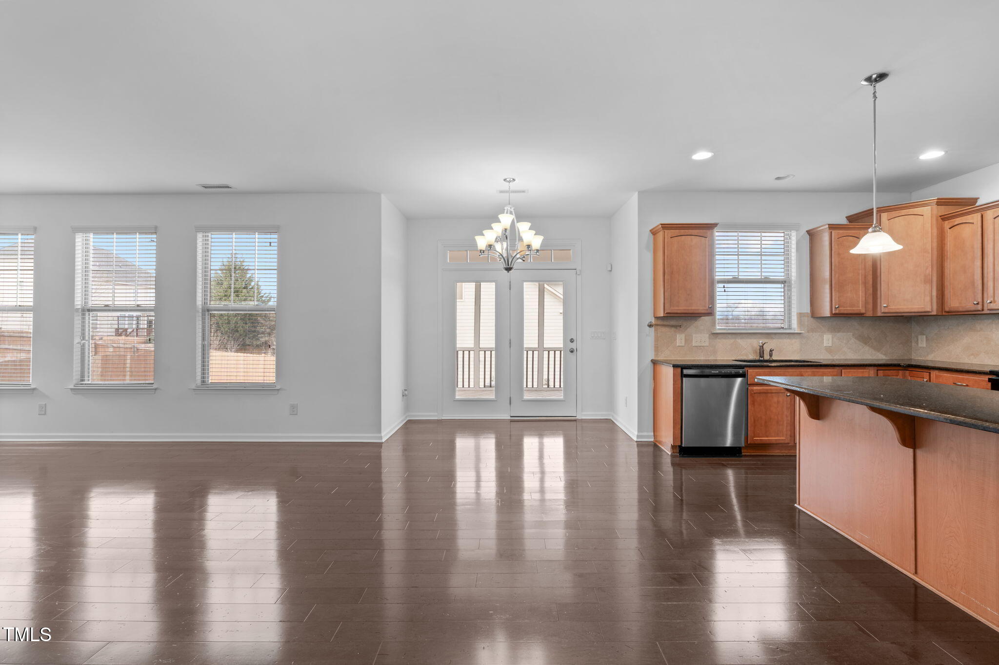 4139 Davis Meadow Street Raleigh, NC 27616 - Photo 9 of 43 a large kitchen with granite countertop a stove a sink wooden floor dining table and chairs