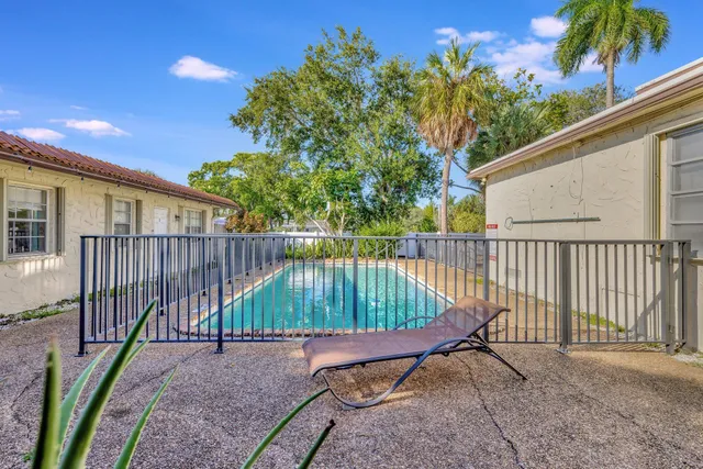 a view of a backyard with table and chairs and a large tree
