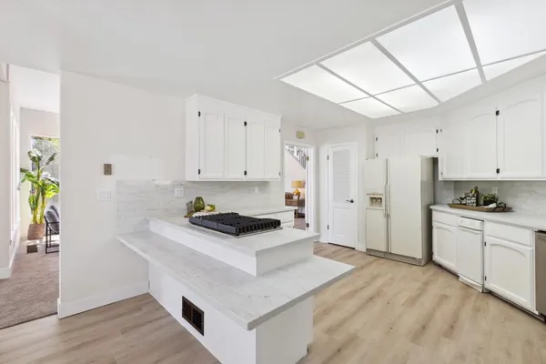 a kitchen with stainless steel appliances granite countertop a stove a sink and a refrigerator