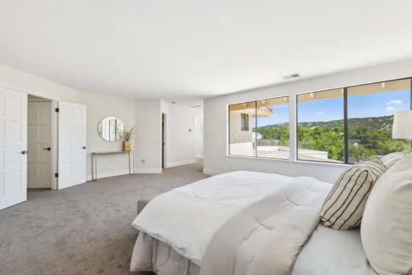 a spacious bedroom with a bed and large window