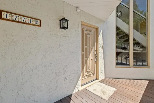 a view of a hallway with wooden floor and a bathroom