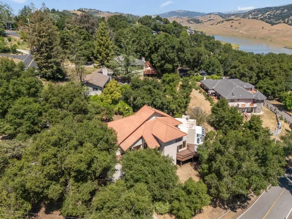 an aerial view of a house with a yard and lake view