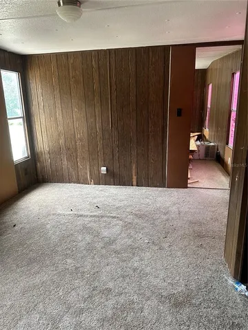 a bedroom with a bed and a flat tv screen on dresser