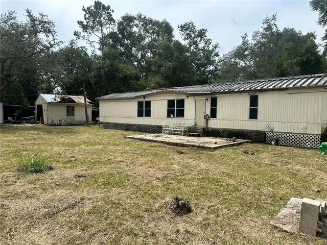 a view of a house with a yard and sitting area