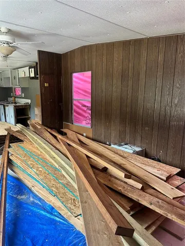 a view of hallway with windows and chandelier fan