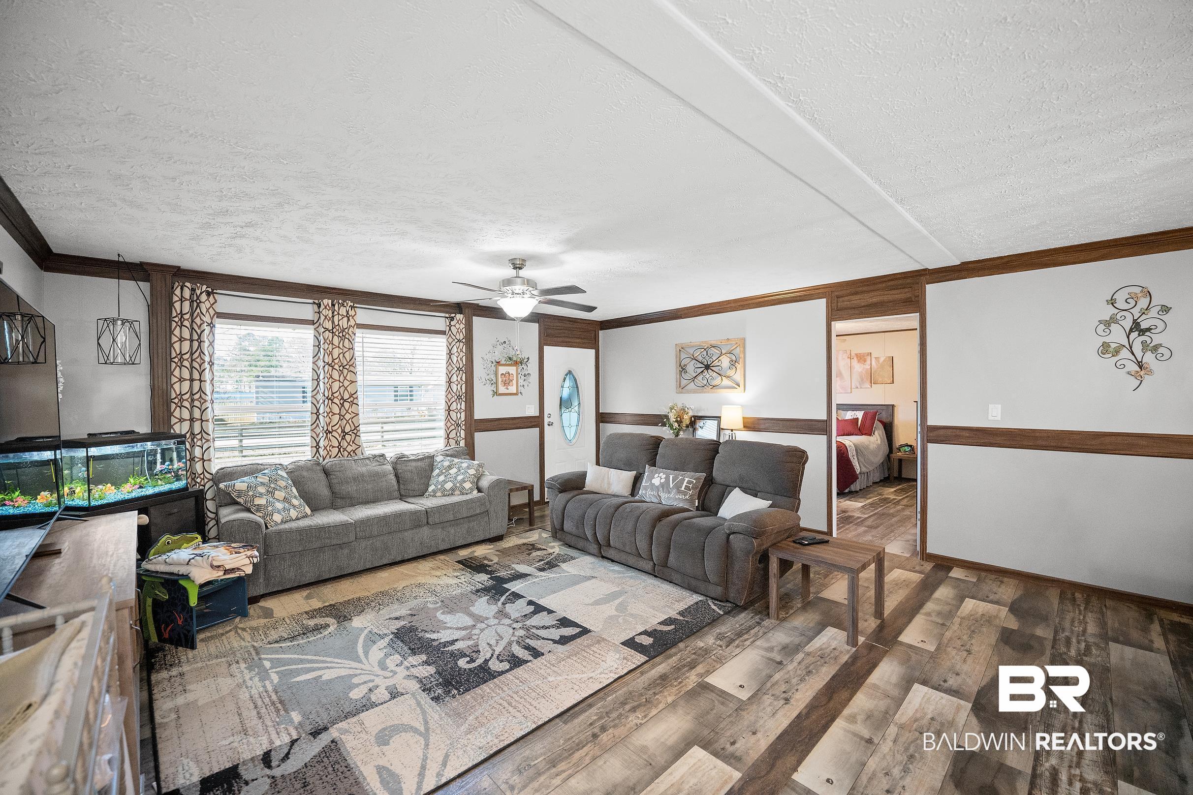 8630 Allison Lane Wilmer, AL 36587 - Photo 8 of 31 Living room with a textured ceiling, hardwood / wood-style flooring, crown molding, and a ceiling fan