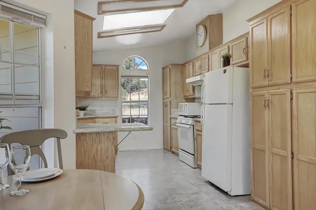 a kitchen with stainless steel appliances granite countertop a sink stove and cabinets