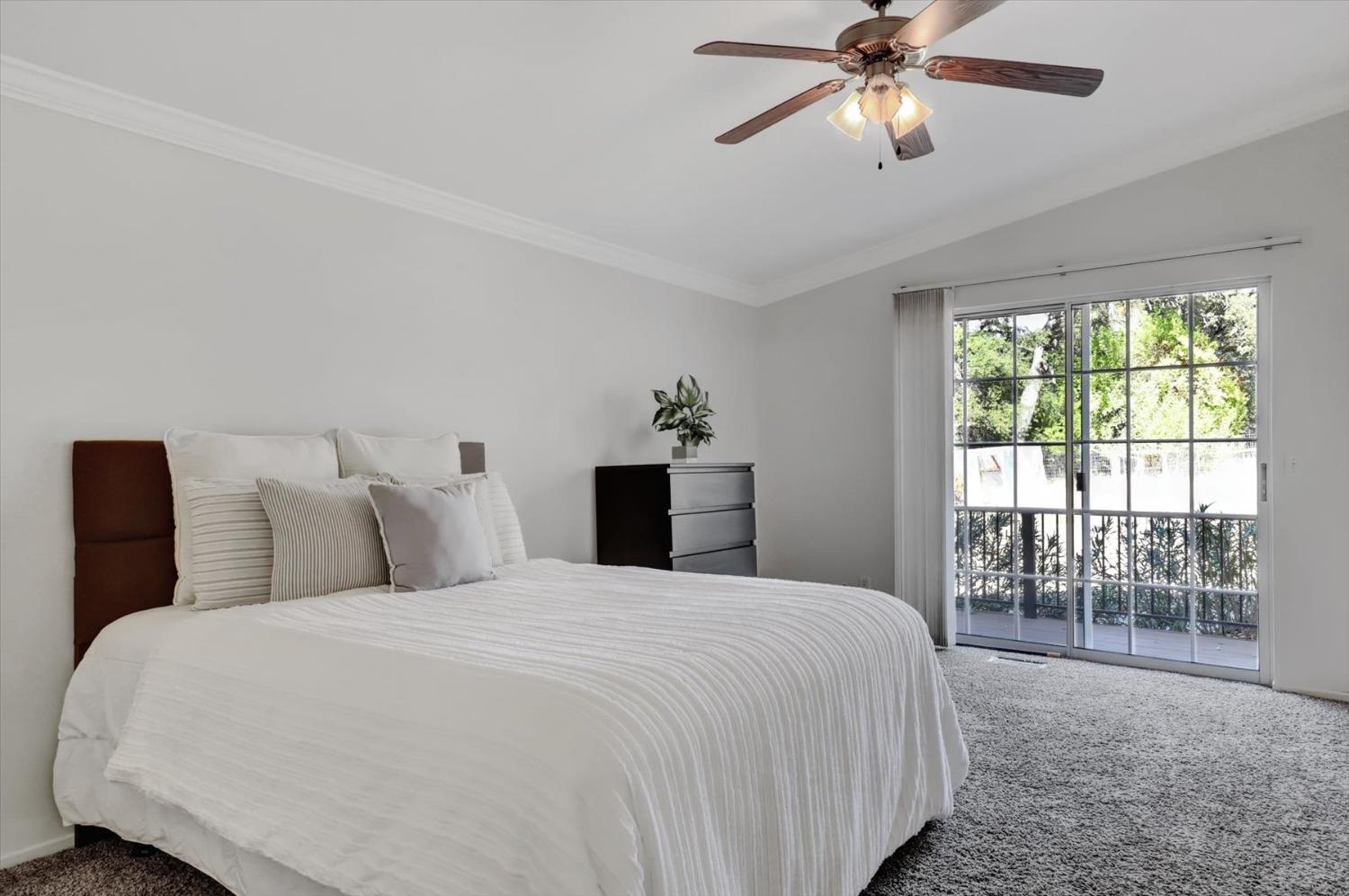 16260 Hillaire Road Rough and Ready, CA 95975 - Photo 10 of 45 a bedroom with a large bed and a chandelier fan