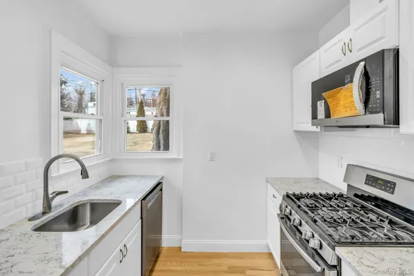 a kitchen with stainless steel appliances granite countertop a sink and a stove top oven