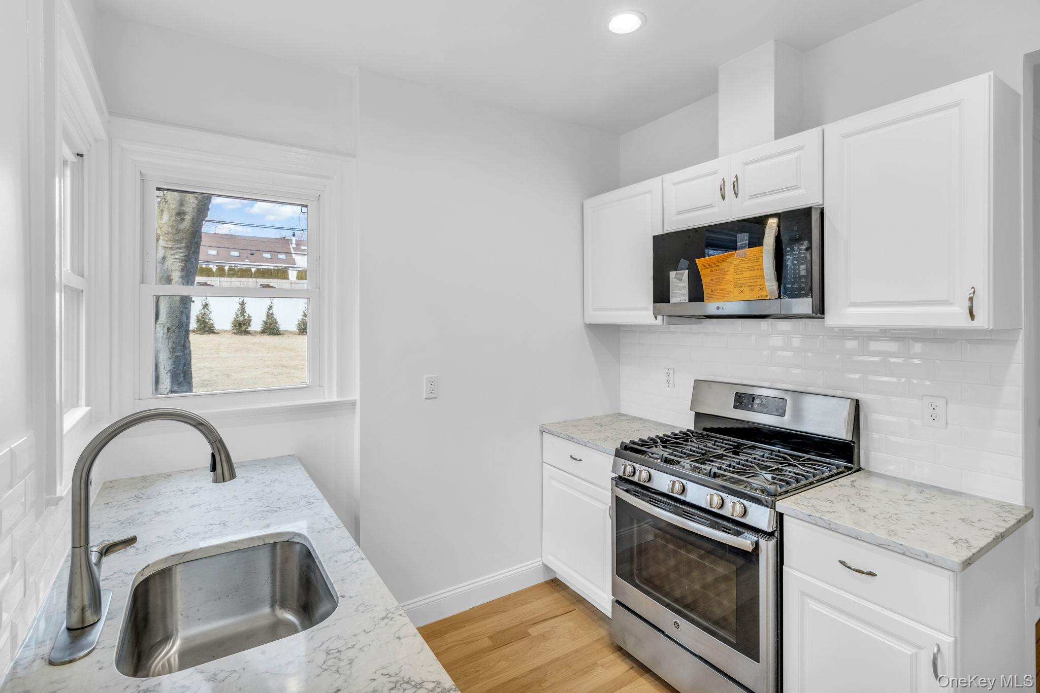 475 Dobbs Ferry Road White Plains, NY 10607 - Photo 12 of 29 a kitchen with stainless steel appliances granite countertop a stove a microwave and a sink