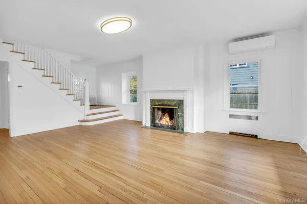 a view of empty room with wooden floor and fireplace