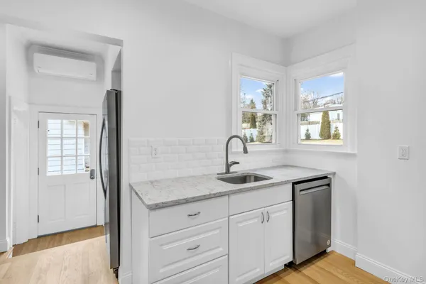 a kitchen with sink and mirror