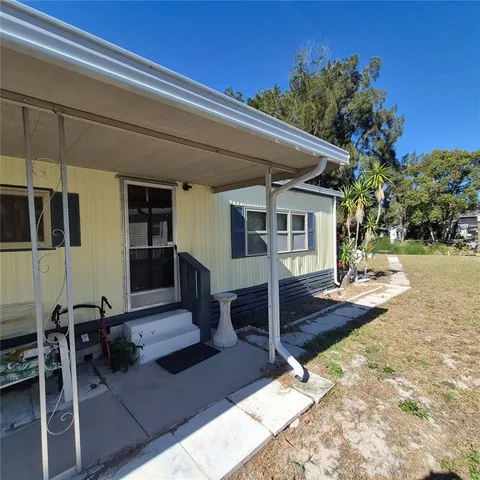 a view of a house with backyard and sitting area