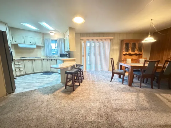 a large kitchen with stainless steel appliances kitchen island granite countertop a sink refrigerator and cabinets
