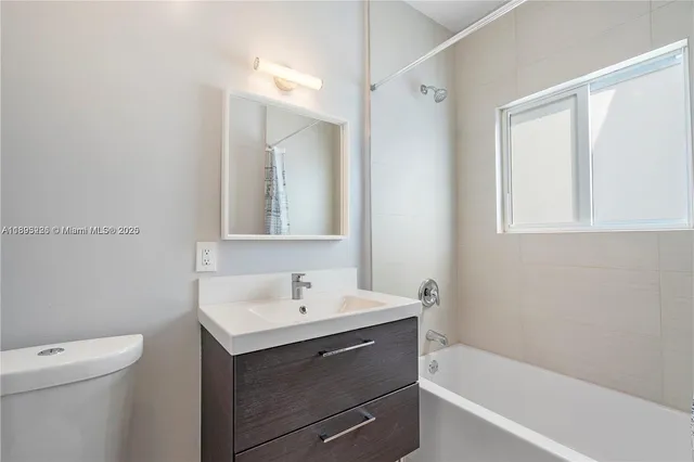 a bathroom with a sink mirror vanity and toilet