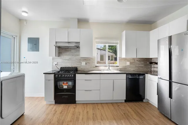 a kitchen with granite countertop a refrigerator stove top oven and sink