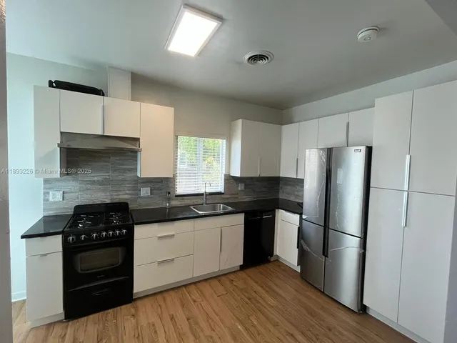 a kitchen with stainless steel appliances a refrigerator sink and cabinets