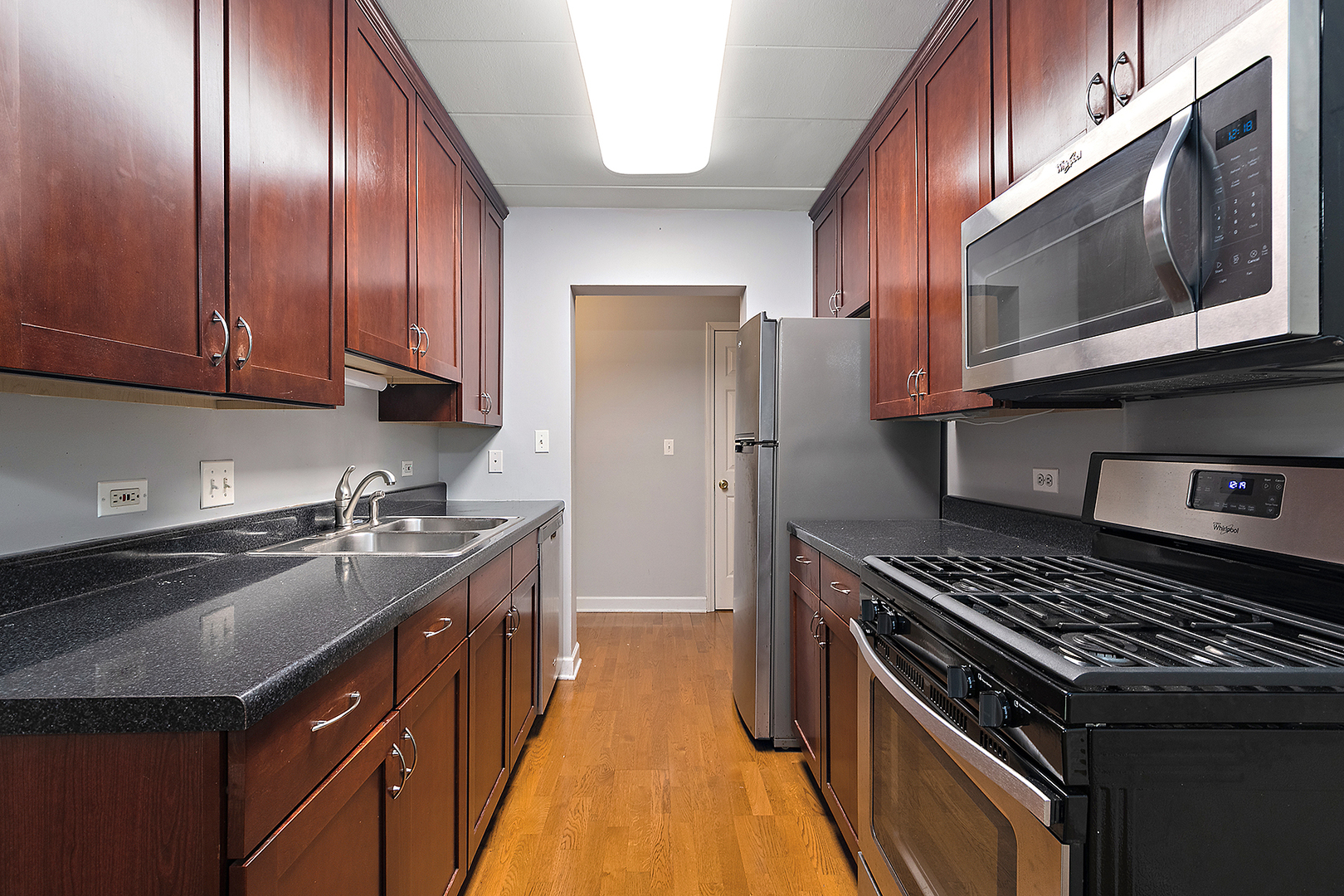 1000 South Lorraine Road, Unit 110 Wheaton, IL 60189 - Photo 11 of 29 a kitchen with a sink stove top oven and wooden cabinets