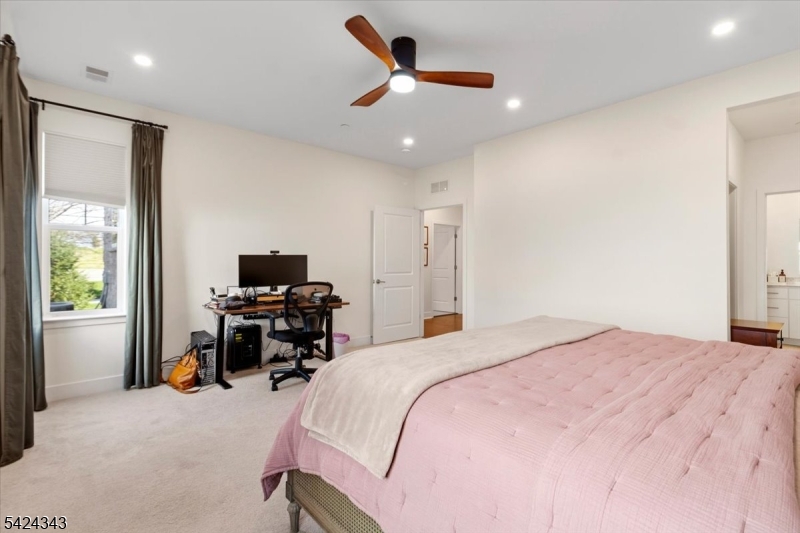 11 Veterans Way, Unit 111 Morris Plains, NJ 07950 - Photo 17 of 21 a bedroom with a bed desk and a flat screen tv