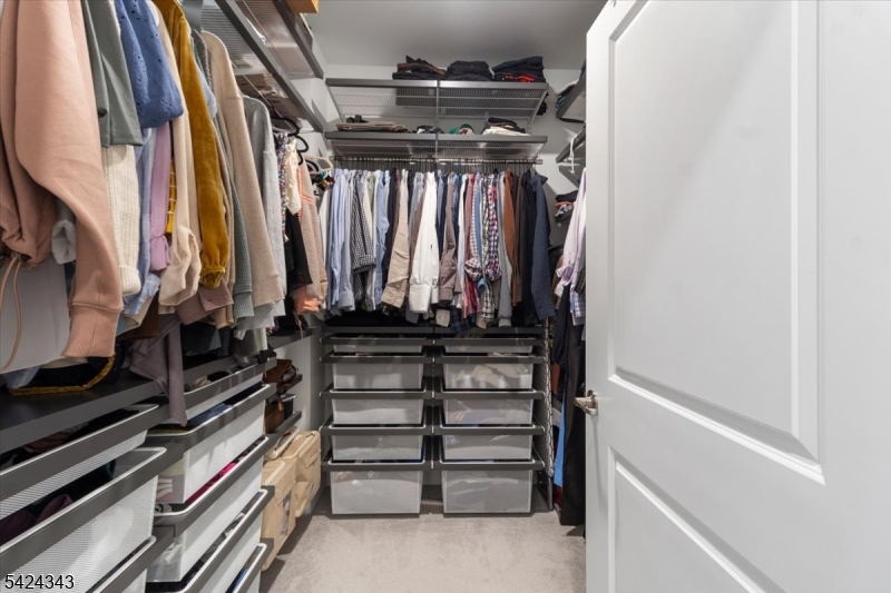 11 Veterans Way, Unit 111 Morris Plains, NJ 07950 - Photo 18 of 21 a view of walk in closet with clothes and shoes