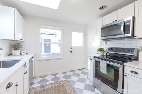 a kitchen with stainless steel appliances a stove a microwave sink and cabinets