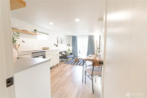 a living room with furniture and a refrigerator