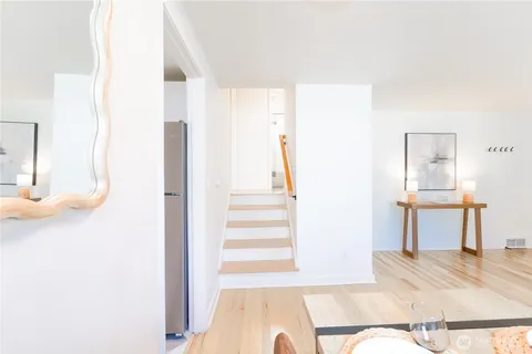 a view of a bedroom with wooden floor and furniture