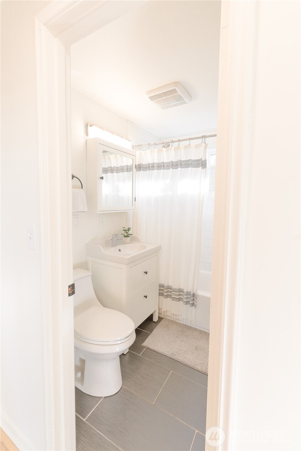 6012 40th Avenue Northeast Seattle, WA 98115 - Photo 10 of 28 a bathroom with a toilet a sink and mirror
