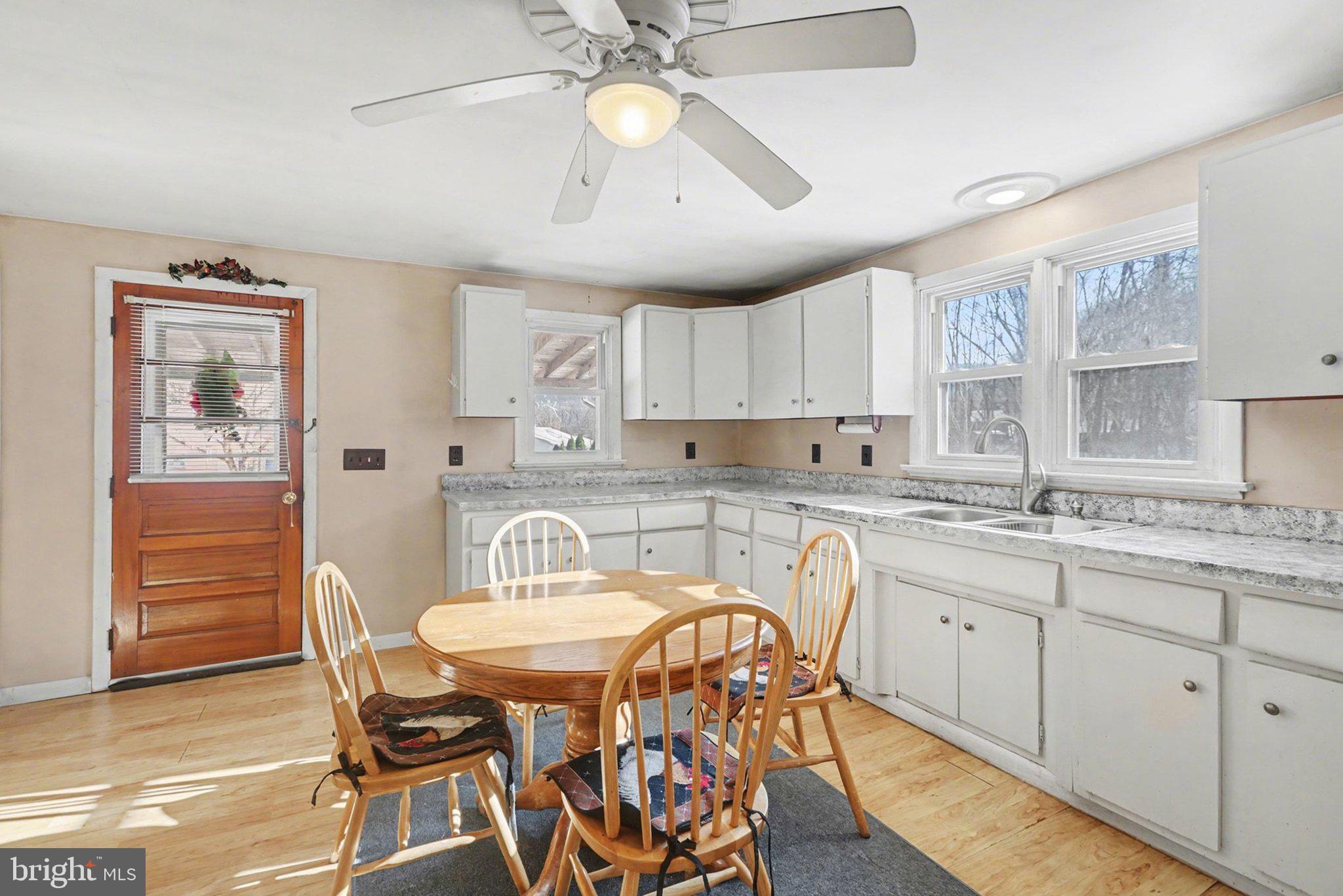 908 Red Hill Road Dauphin, PA 17018 - Photo 11 of 33 a kitchen with stainless steel appliances granite countertop a sink a stove a dining table and chairs with wooden floor