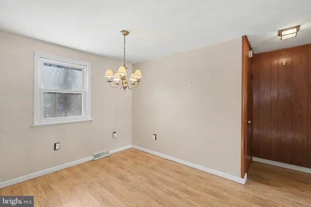 a view of a room with wooden floor and chandelier