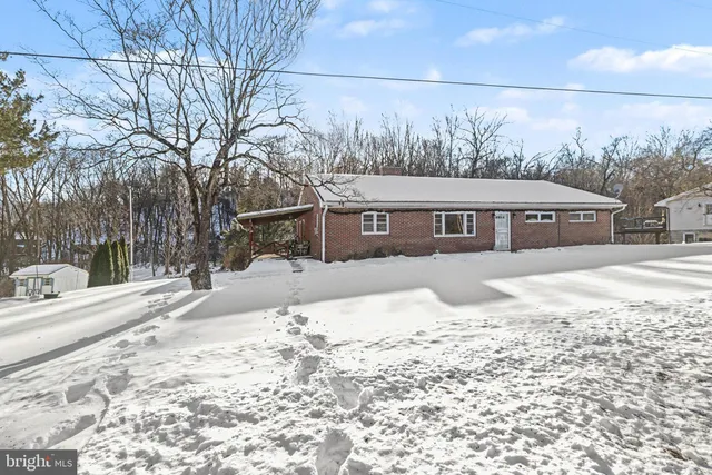 a front view of a house with a yard covered in snow