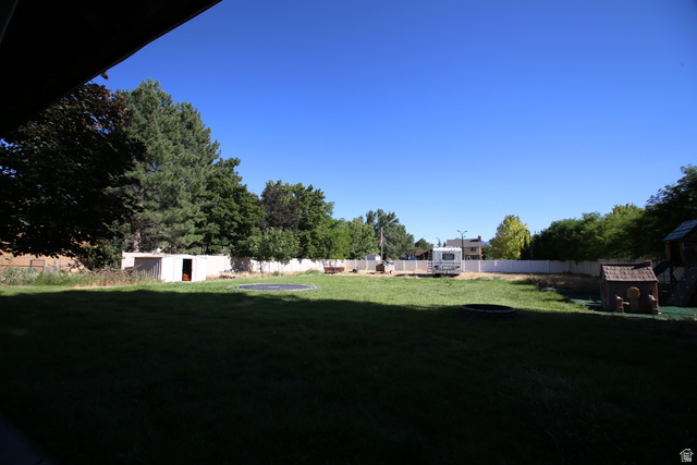 1612 East 450 South Springville, UT 84663 - Photo 5 of 48 Expansive backyard featuring a manicured lawn, perimeter fencing, mature trees, and a storage shed