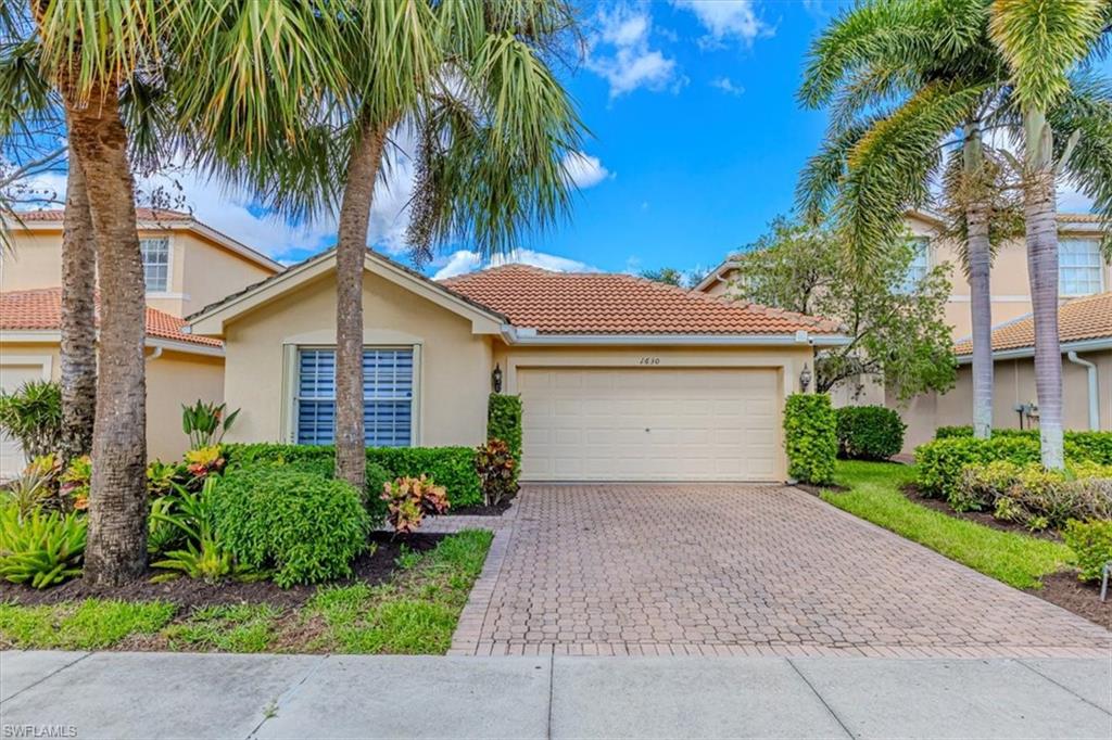 1630 Triangle Palm Terrace Naples, FL 34119 - Photo 1 of 24 a front view of a house with a garden