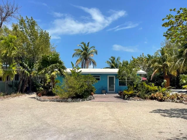 a view of a house with a yard and potted plants