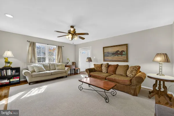 a living room with furniture a flat screen tv and a large window