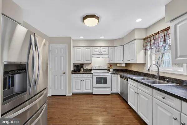 a living room with furniture a chandelier fan and a window