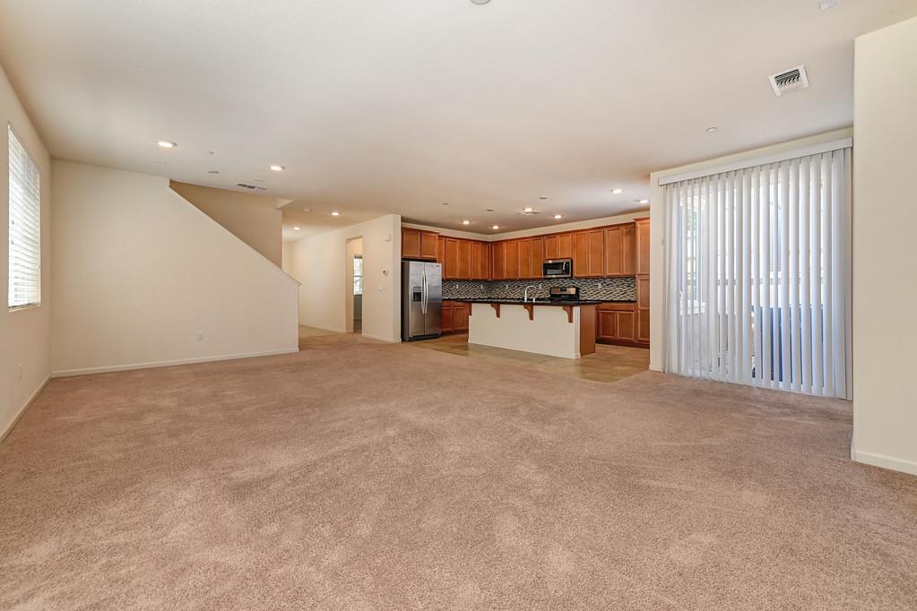 3231 Foxton Way Rancho Cordova, CA 95670 - Photo 10 of 29 an empty room with furniture and a kitchen
