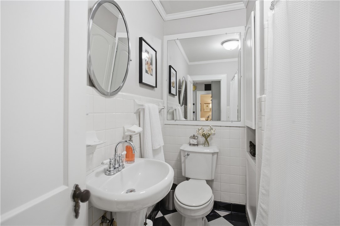 310 Retreat Street Westminster, SC 29693 - Photo 17 of 46 This bathroom features a classic pedestal sink and black and white checkered floor for a timeless appeal.