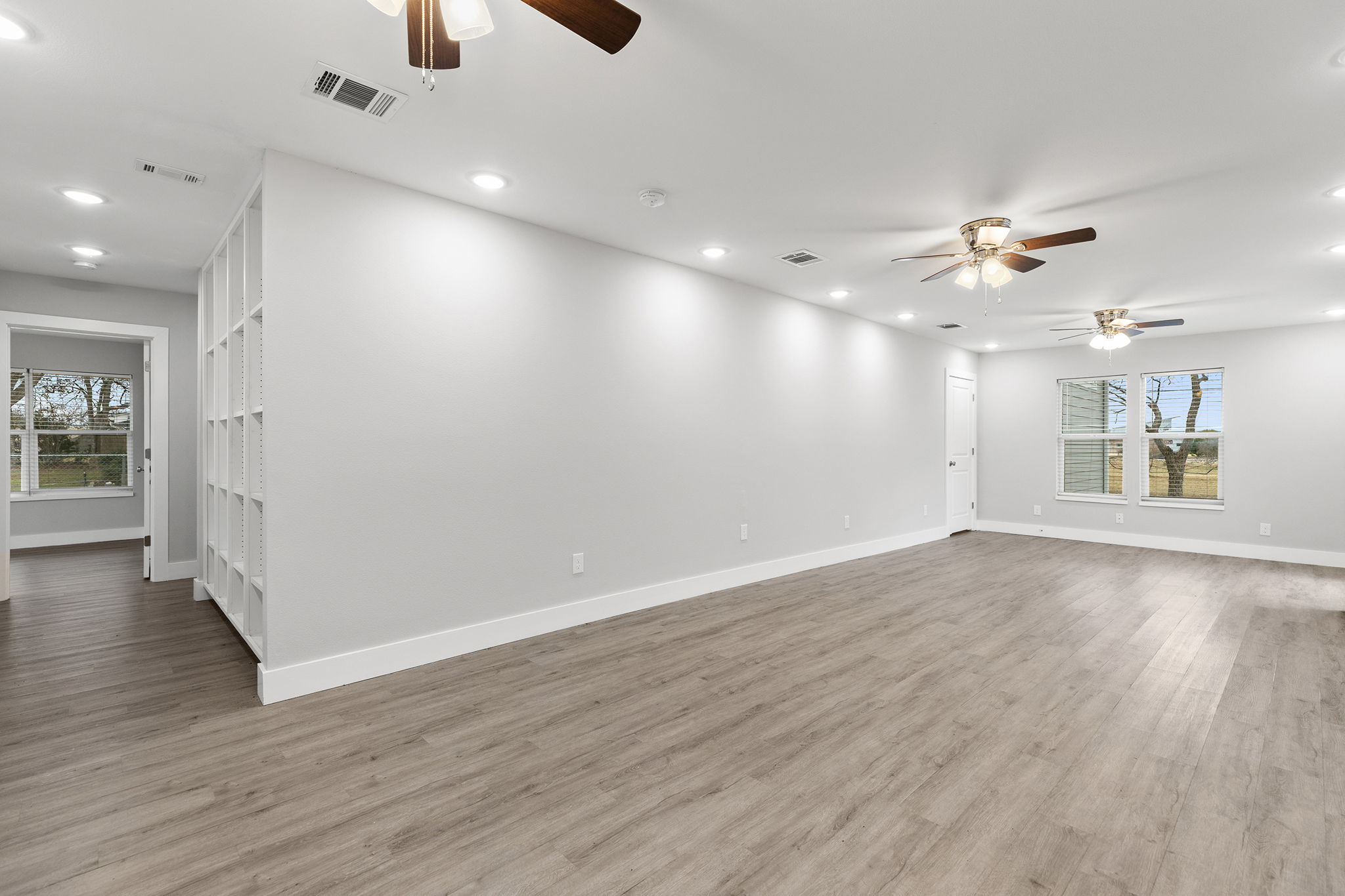 813 Central Avenue Elgin, TX 78621 - Photo 9 of 22 Unfurnished room featuring plenty of natural light, a ceiling fan, light wood-style floors, and recessed lighting