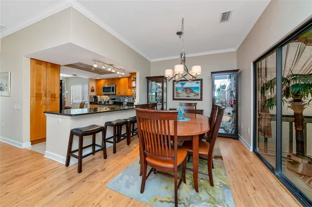 a dining room with furniture a chandelier and wooden floor