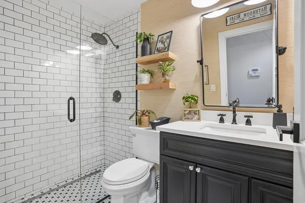 a bathroom with a sink a toilet and mirror
