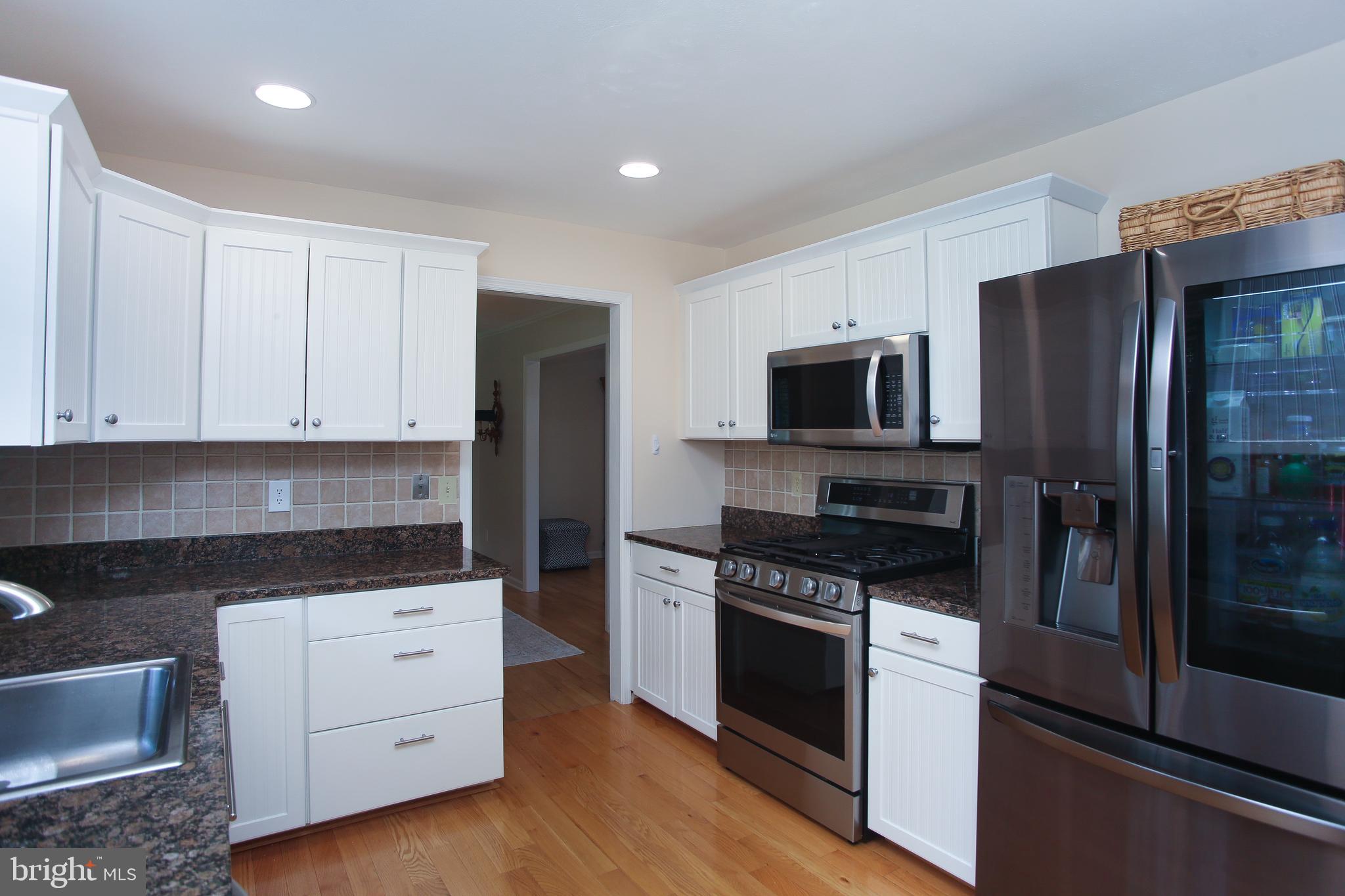 4 Indian Run Road Princeton Junction, NJ 08550 - Photo 11 of 43 a kitchen with white cabinets and stainless steel appliances